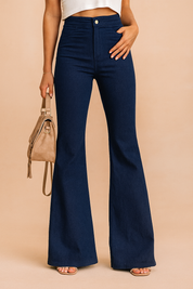 High-waisted navy blue flared pants with a sleek tailored fit, front button closure, and clean hemline, styled with open-toe sandals and a beige suede handbag.
