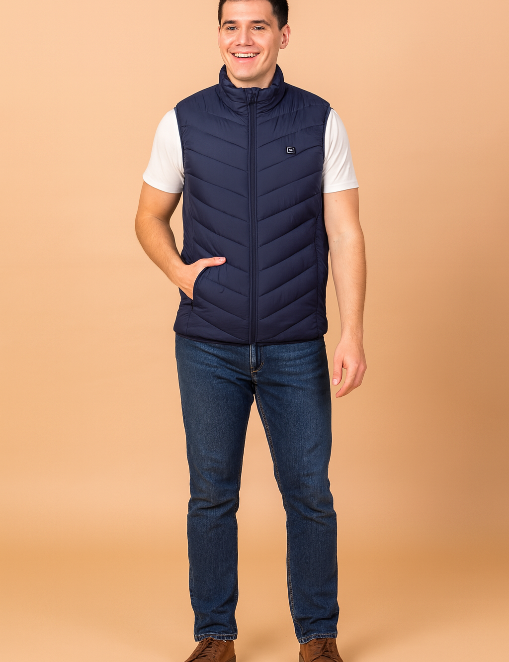 Men’s navy blue heated vest with chevron quilted design, full zip closure, and high collar. Paired with jeans and brown casual shoes for a modern, practical look