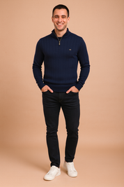 Men’s navy ribbed quarter-zip sweater with vertical textured patterns, styled with slim-fit dark jeans and white sneakers.