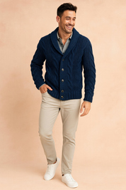 Navy blue cable knit cardigan with shawl collar and button front closure, styled over a light gray shirt with beige chinos and white sneakers.