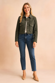 Olive green cropped button-up wool jacket with flap pockets, styled with a white tee, blue jeans, and beige heels.