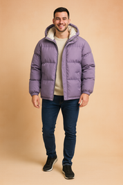 Purple hooded puffer jacket with cream inner lining, front zipper closure, and side pockets, styled casually with a sweater, jeans, and sneakers.