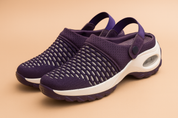 Breathable purple mesh slip-on clogs with a white cushioned sole, featuring a scale-like knit pattern, supportive heel strap, and visible air cushion unit.