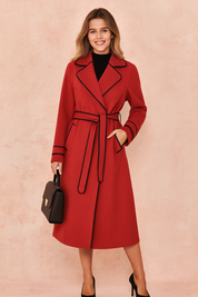 Red belted trench coat with black contrast trim, styled with black heels and a structured handbag