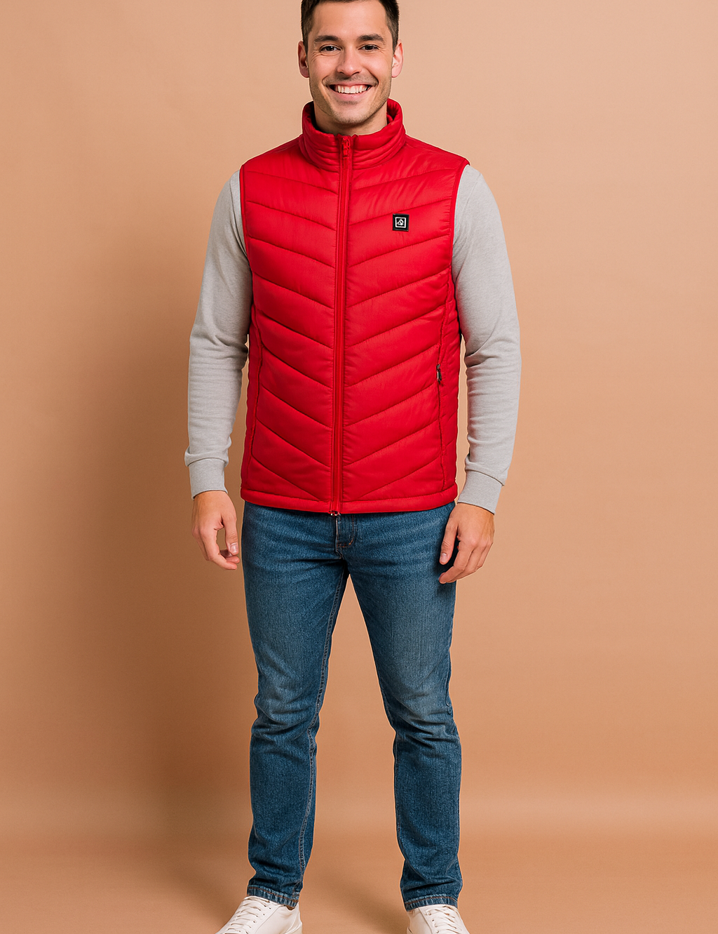 Men’s red heated vest with chevron quilted design, full zip closure, and high collar. Paired with jeans and brown casual shoes for a modern, practical look