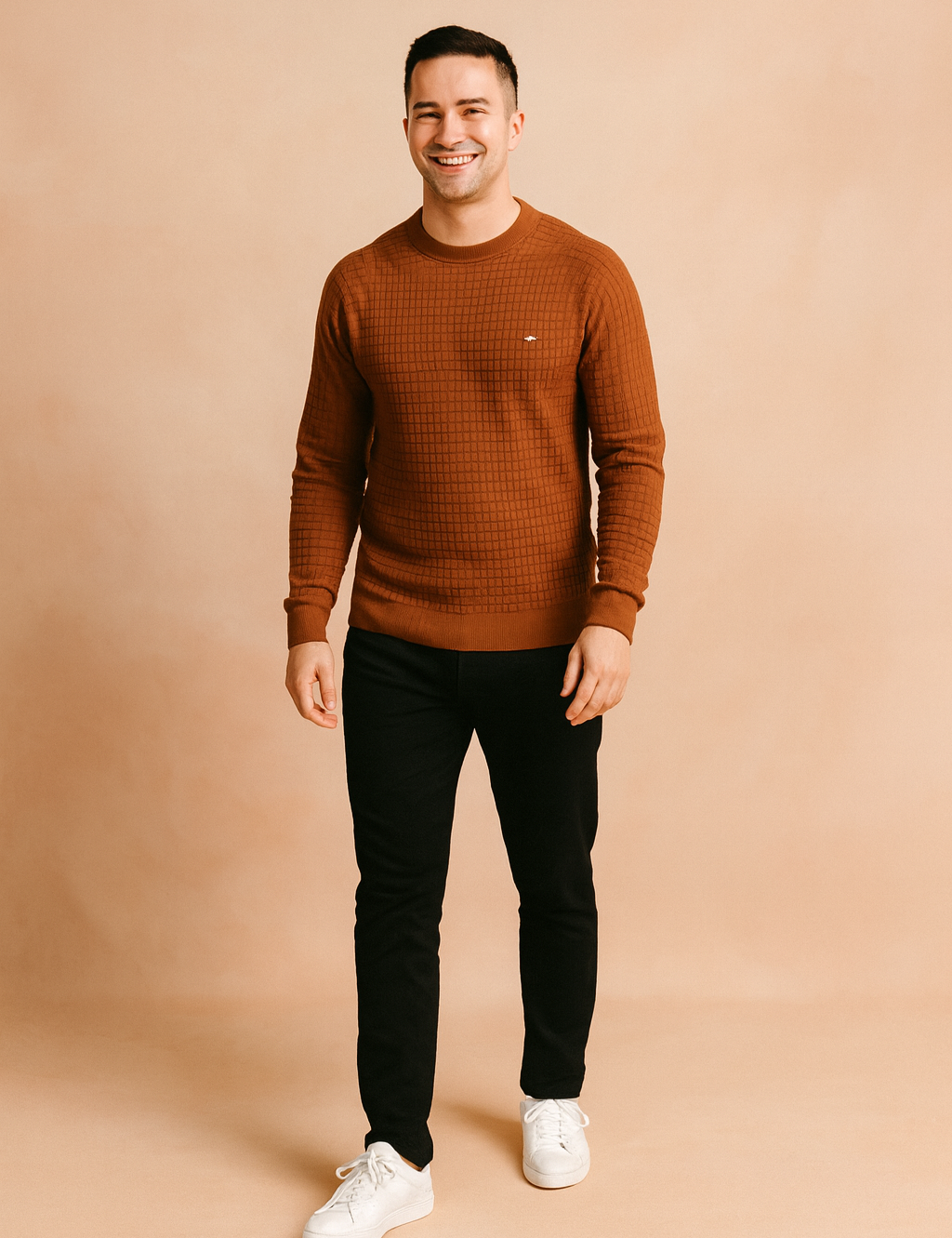 Men’s rust brown textured crewneck sweater with grid knit pattern, styled with slim-fit black jeans and white sneakers.