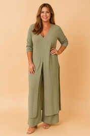 Sage green V-neck longline coord set with front slit detailing and wide-leg trousers, made from soft flowy fabric and styled with rolled sleeves and nude block-heel sandals.