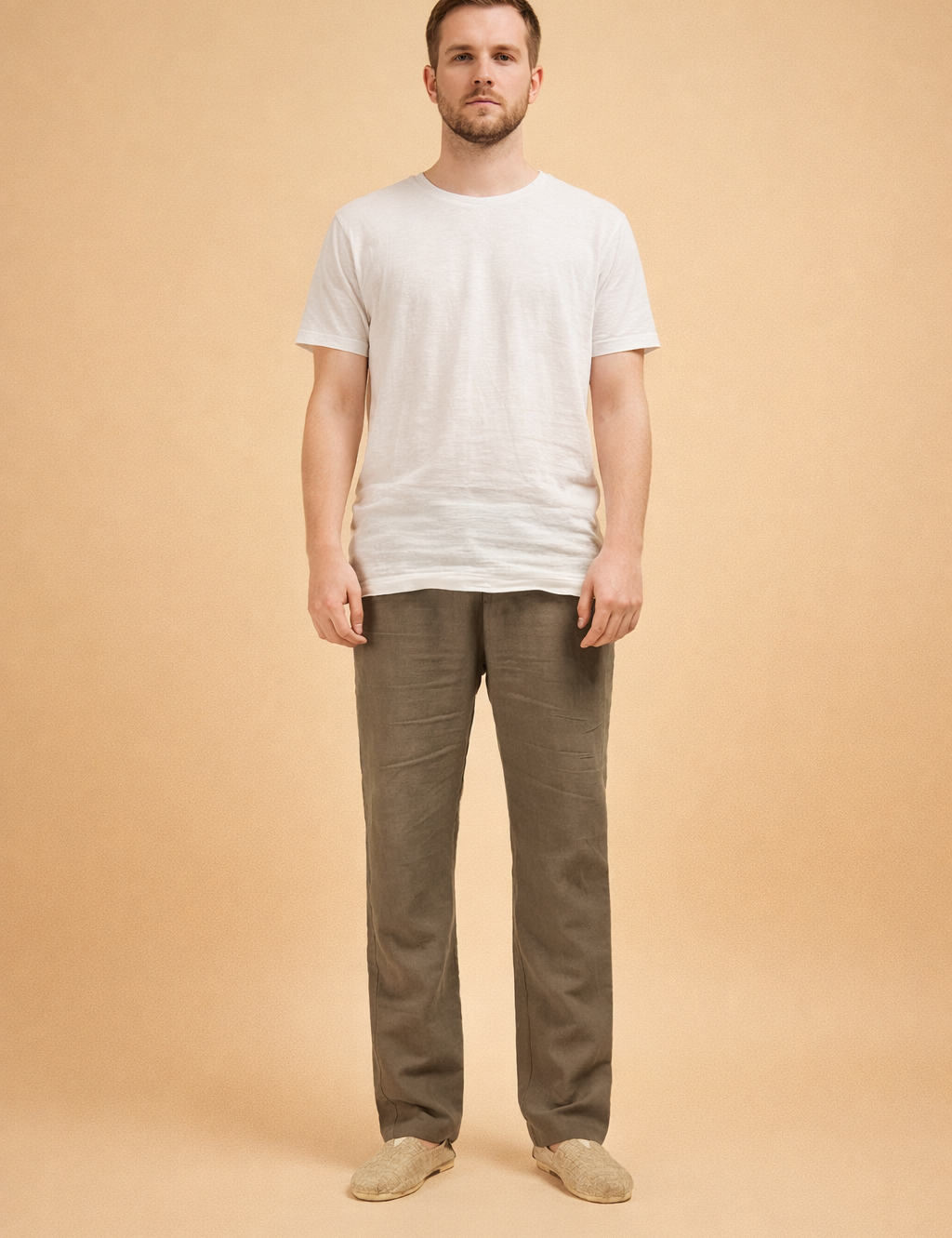 Men’s straight-leg trousers with a relaxed tailored cut, smooth front, clean waistband, and full-length legs, styled with a minimal top and neutral slip-on footwear for a refined everyday look.