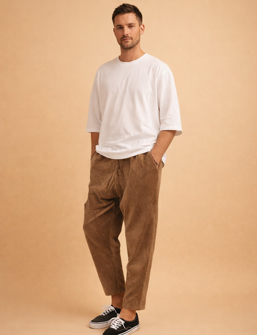 Relaxed-fit corduroy trousers with a straight-leg cut, soft vertical rib texture, mid-rise waist, and cropped ankle length, styled with a clean oversized short-sleeve top and low-profile lace-up sneakers for a modern casual look.