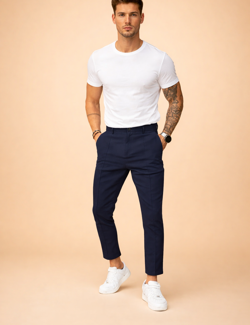 Slim-fit tailored navy trousers with a clean front crease, ankle-length cut, and classic low-profile white sneakers for a modern smart-casual look.