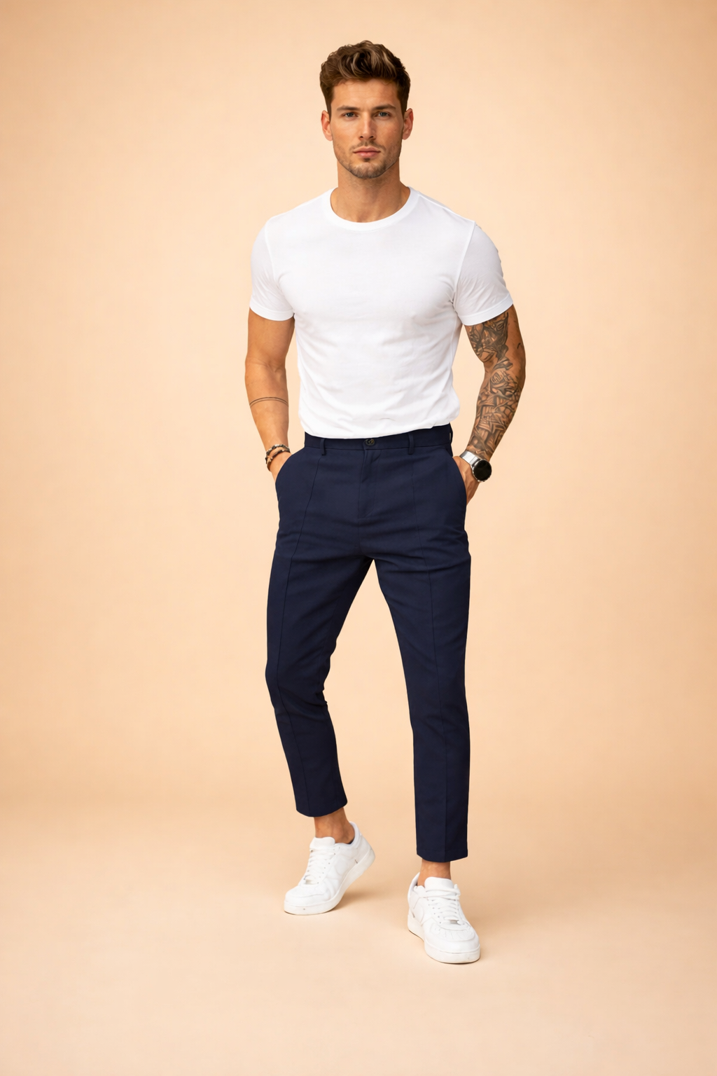 Slim-fit tailored navy trousers with a clean front crease, ankle-length cut, and classic low-profile white sneakers for a modern smart-casual look.