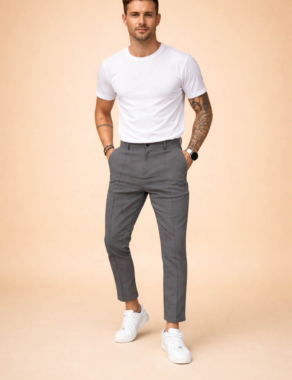 Slim-fit tailored trousers with a clean waistband, tapered leg, and cropped ankle length, styled with a fitted short-sleeve top and minimalist low-profile sneakers for a modern smart-casual look.