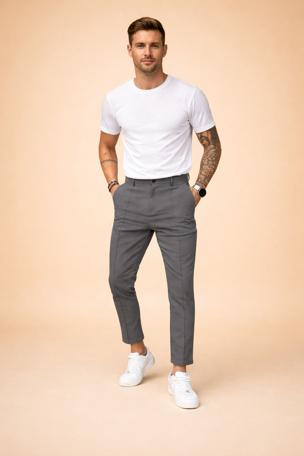 Slim-fit tailored trousers with a clean waistband, tapered leg, and cropped ankle length, styled with a fitted short-sleeve top and minimalist low-profile sneakers for a modern smart-casual look.