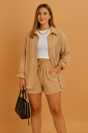 Textured co-ord set featuring a button-up long-sleeve shirt with relaxed cuffs and drawstring shorts, paired with a ribbed white crop top and accessorized with a structured black handbag.