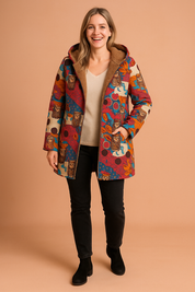 Colorful fleece-lined open-front hooded coat with abstract multicolor tribal print in red, orange, blue, and cream, featuring long sleeves and a cozy soft brown teddy lining.