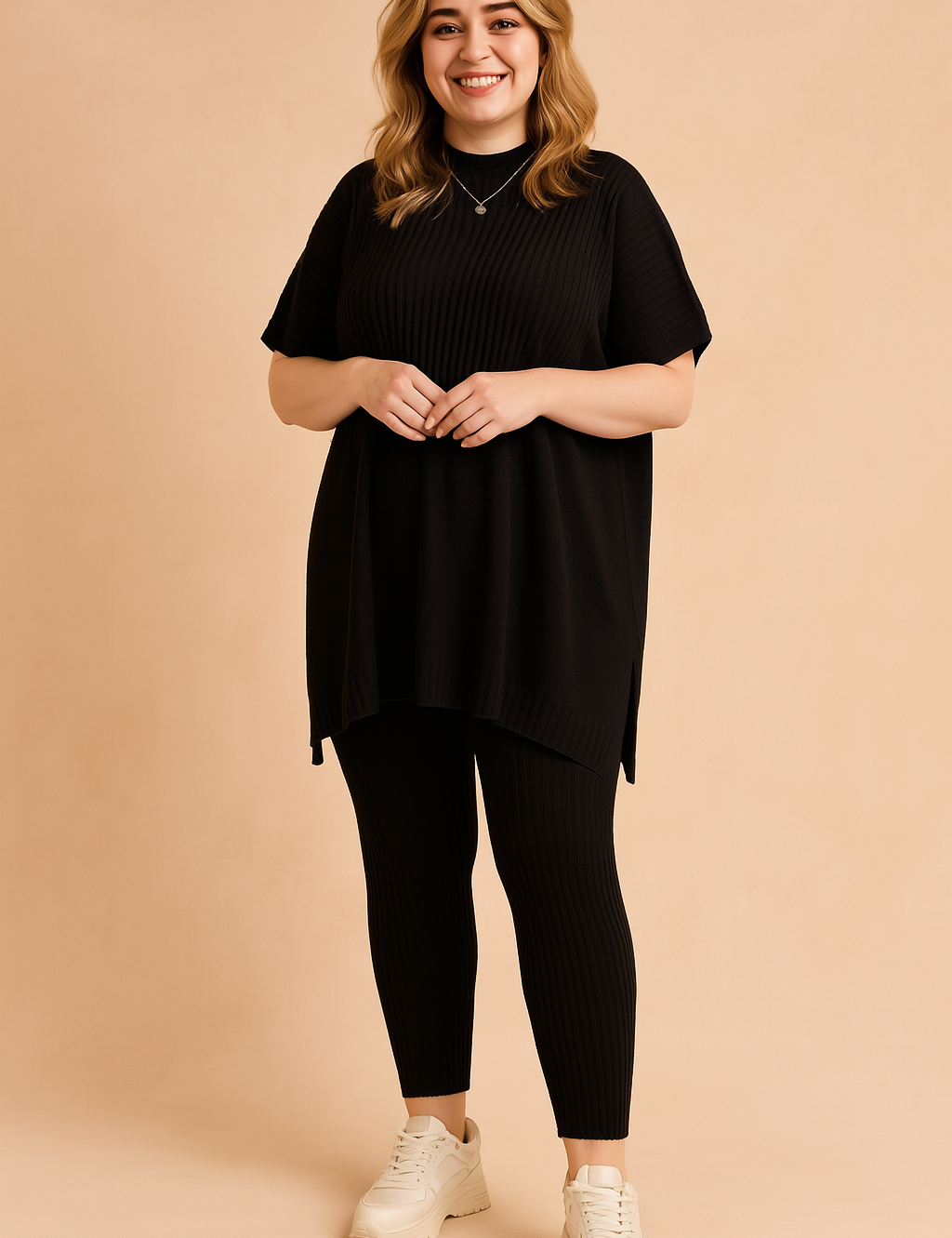 Two-piece ribbed knit co-ord set featuring a loose-fit short-sleeve tunic top with a high-low hem and matching fitted ankle-length leggings, styled with chunky white sneakers.