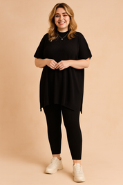 Two-piece ribbed knit co-ord set featuring a loose-fit short-sleeve tunic top with a high-low hem and matching fitted ankle-length leggings, styled with chunky white sneakers.