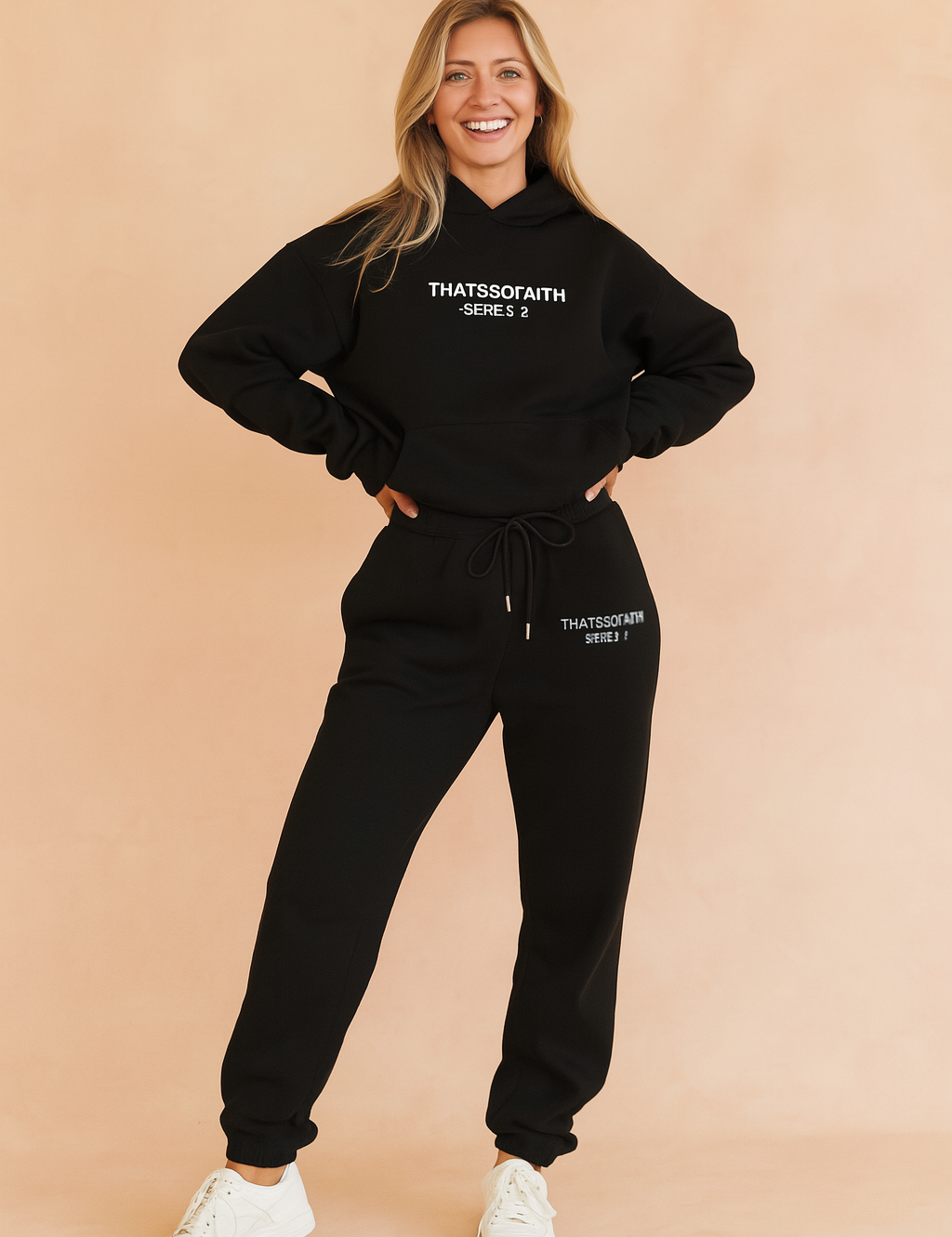 Two-piece black co-ord set featuring a relaxed-fit hoodie and high-waisted jogger pants with drawstring waist, both embellished with minimal white logo text for a clean streetwear look.