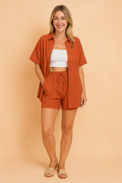 Two-piece coord set featuring a relaxed short-sleeve button-up shirt with front pocket and matching high-waist drawstring shorts, both in a brown hue with a soft woven texture.