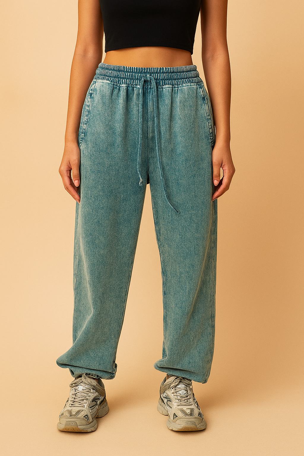 Relaxed-fit teal acid-wash jogger sweatpants featuring an elastic waistband with drawstring, straight leg silhouette, and rolled cuffs, paired with chunky gray athletic sneakers.