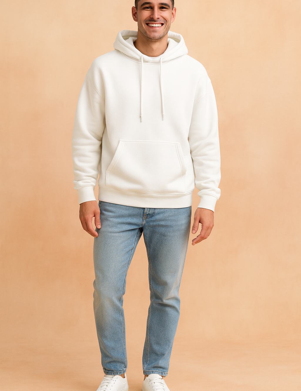 Men’s white pullover hoodie with kangaroo pocket and drawstring hood, styled with light blue jeans and white sneakers.