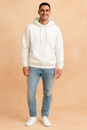 Men’s white pullover hoodie with kangaroo pocket and drawstring hood, styled with light blue jeans and white sneakers.