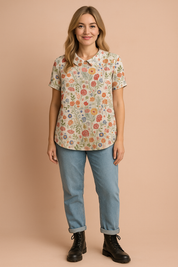 White linen blouse with a Peter Pan collar, detailed with a vibrant multicolor floral pattern in red, orange, blue, and yellow blooms.