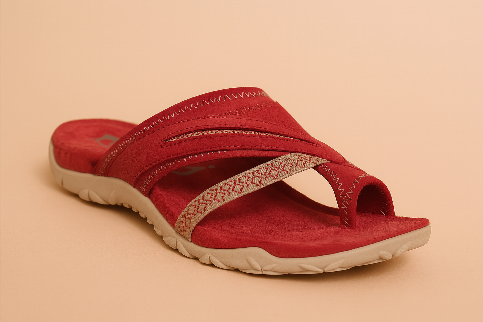 Red suede slip-on sandal with a beige patterned toe loop strap, dual arch bands with zigzag stitching, and a textured beige rubber sole.