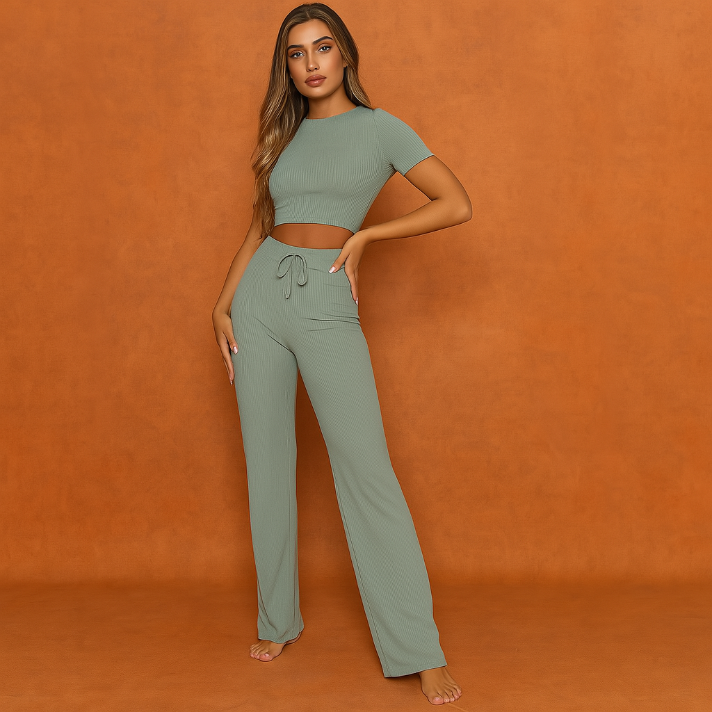 Sage green ribbed loungewear set featuring a fitted crop top with short sleeves and high-waisted drawstring pants with a wide-leg silhouette, made from a soft stretch fabric.