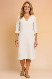 Elegant V-neck three-quarter sleeve shift dress in soft textured fabric, cut just below the knee with a relaxed straight silhouette, subtle seam details, and minimalistic clean finish — ideal for effortless day-to-evening styling.