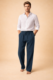 Lightweight sand-beige linen trousers with a relaxed straight-leg cut, elastic waistband with adjustable drawstring, soft natural fabric texture, full-length drape, and clean minimalist finish suitable for warm-weather styling.
