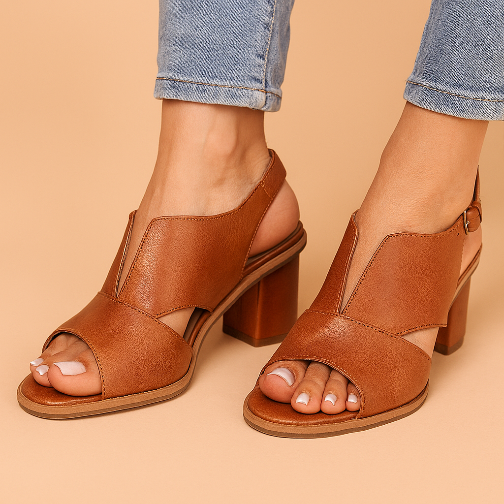 Tan leather block heel sandals with a V-cut front design and slingback strap, featuring smooth polished finish and crisscross detail at the toe.