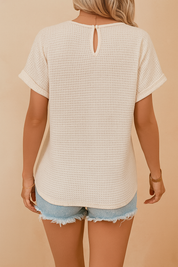 Cream waffle knit short-sleeve top with keyhole button closure at the back, paired with frayed hem light wash denim shorts.