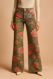 High-waisted wide-leg jeans with a bold leopard print base and vibrant all-over floral pattern, featuring oversized pink roses, blue daisies, and green leaves; finished with front pockets and precise stitching.