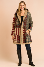Patchwork fleece-lined winter coat in burgundy with beige polka dots, circular mandala and floral print accents, dual front pockets, and button-down closure.