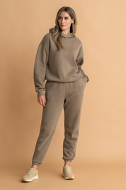 Taupe fleece-lined oversized hoodie and matching high-waisted joggers set with cuffed ankles, crafted in soft cotton-blend fabric featuring a smooth, matte finish and minimal seam detailing.