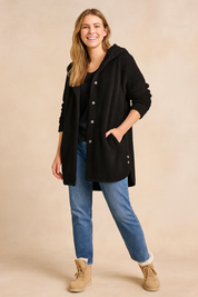 Black quilted button-down hooded jacket for women with long sleeves and side pockets, styled with straight-leg denim jeans and beige lace-up ankle boots