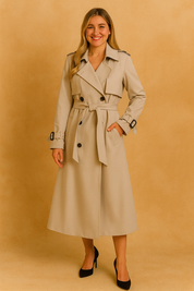 Beige double-breasted trench coat with belt, button closure, and cuff buckles, paired with black pointed heels