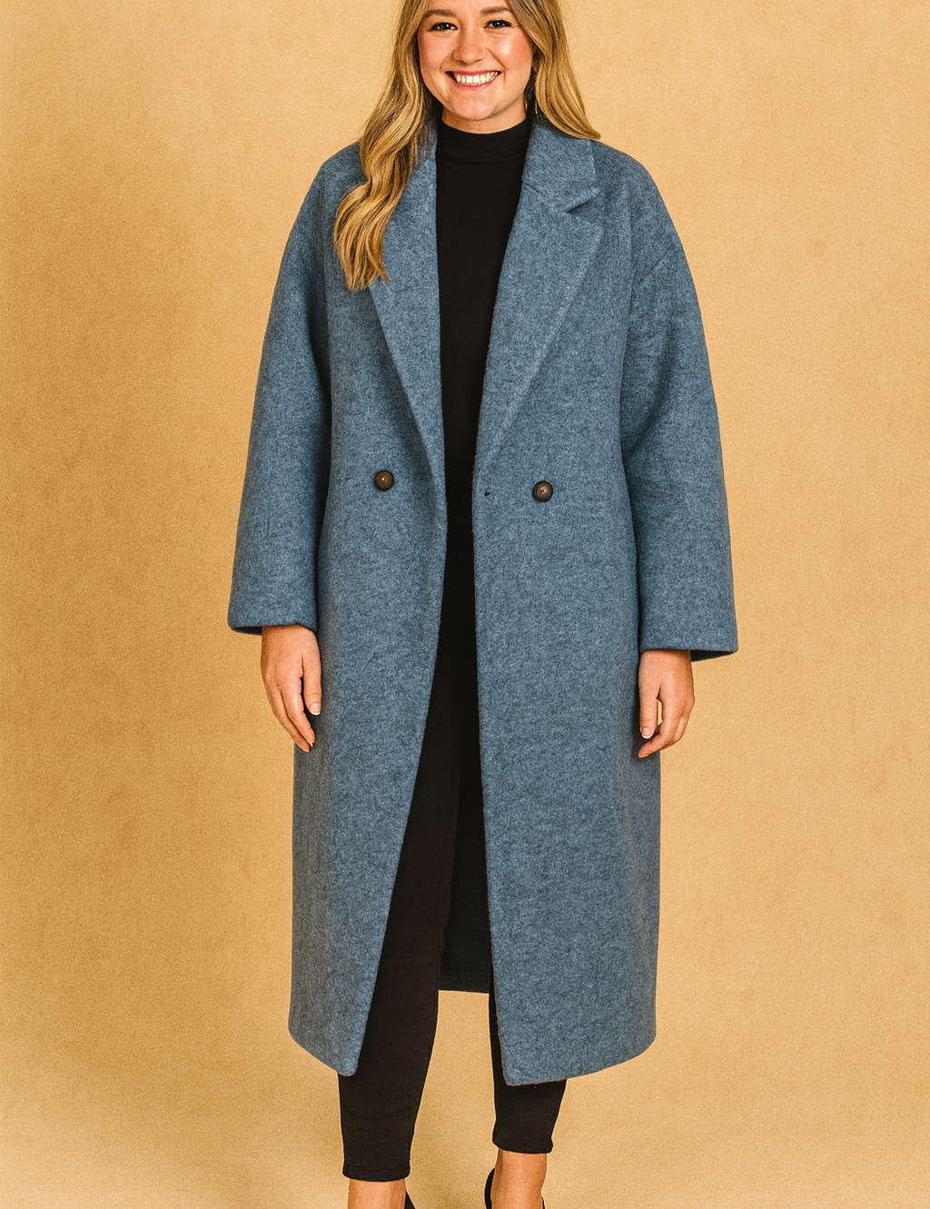 Oversized blue wool coat with button closure, styled with a black turtleneck, slim black trousers, and black pumps.