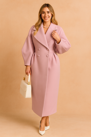 Pastel pink long double-breasted coat with oversized collar and voluminous sleeves, styled with a white handbag and white pointed heels.