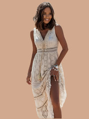 Letnia sukienka maxi w stylu boho z delikatnej koronki w kolorze ecru, zdobiona geometrycznym wzorem, z głębokim dekoltem w serek, haftowanym pasem w talii, ozdobnymi frędzlami i wysokim rozcięciem z przodu dla podkreślenia sylwetki.