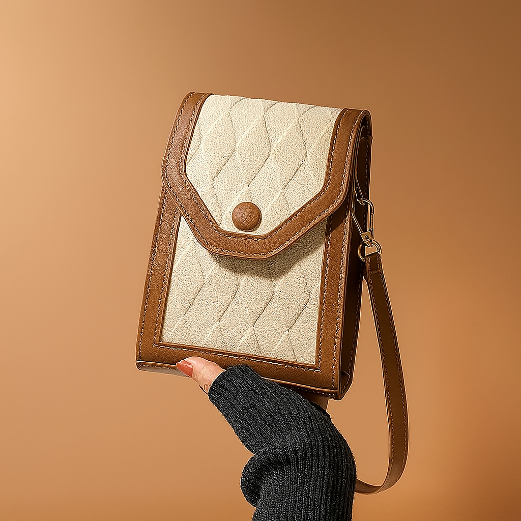 Small vertical tan and camel crossbody bag with quilted diamond-texture fabric front, curved flap with snap button closure, contrast trim, and adjustable leather-look strap.