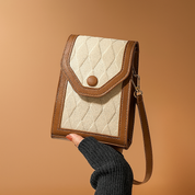 Small vertical tan and camel crossbody bag with quilted diamond-texture fabric front, curved flap with snap button closure, contrast trim, and adjustable leather-look strap.