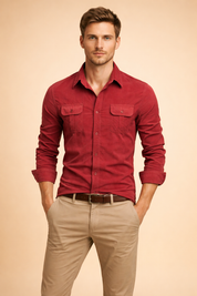 Red long-sleeve button-up shirt with structured collar, dual chest flap pockets, tonal buttons, and tailored fit, paired with beige straight-leg chinos and a brown leather belt.