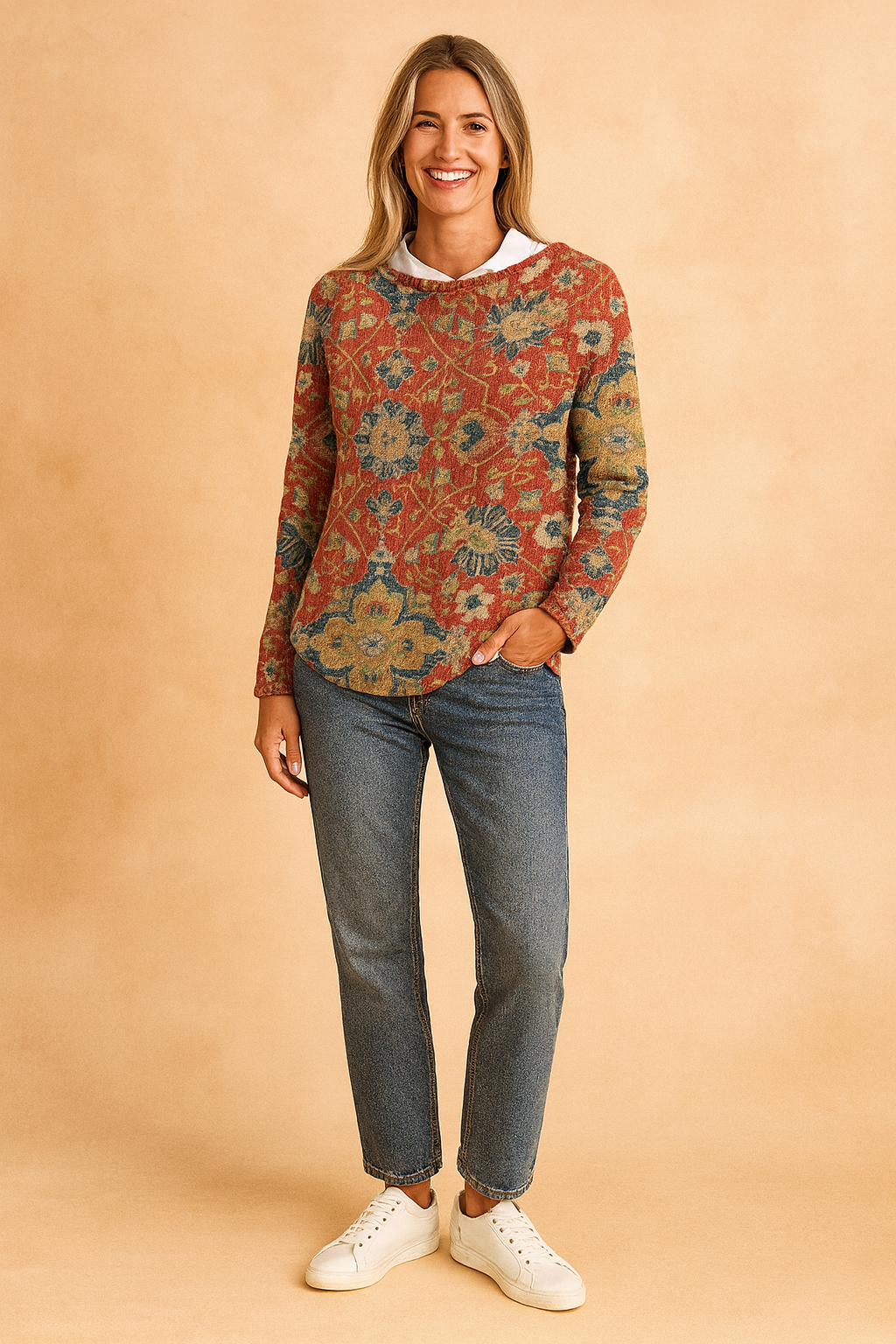 Red floral-pattern knit sweater with intricate blue, yellow, and green motifs, paired with classic blue jeans and white sneakers.