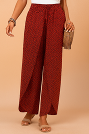 High-waisted red wide-leg pants with a black herringbone-style geometric pattern, featuring an elastic waistband and front drawstring in matching fabric, made from lightweight woven material with a natural drape.