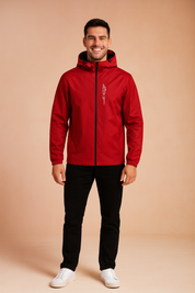 Red hooded softshell jacket with front zipper and logo print, paired with black trousers and white sneakers.