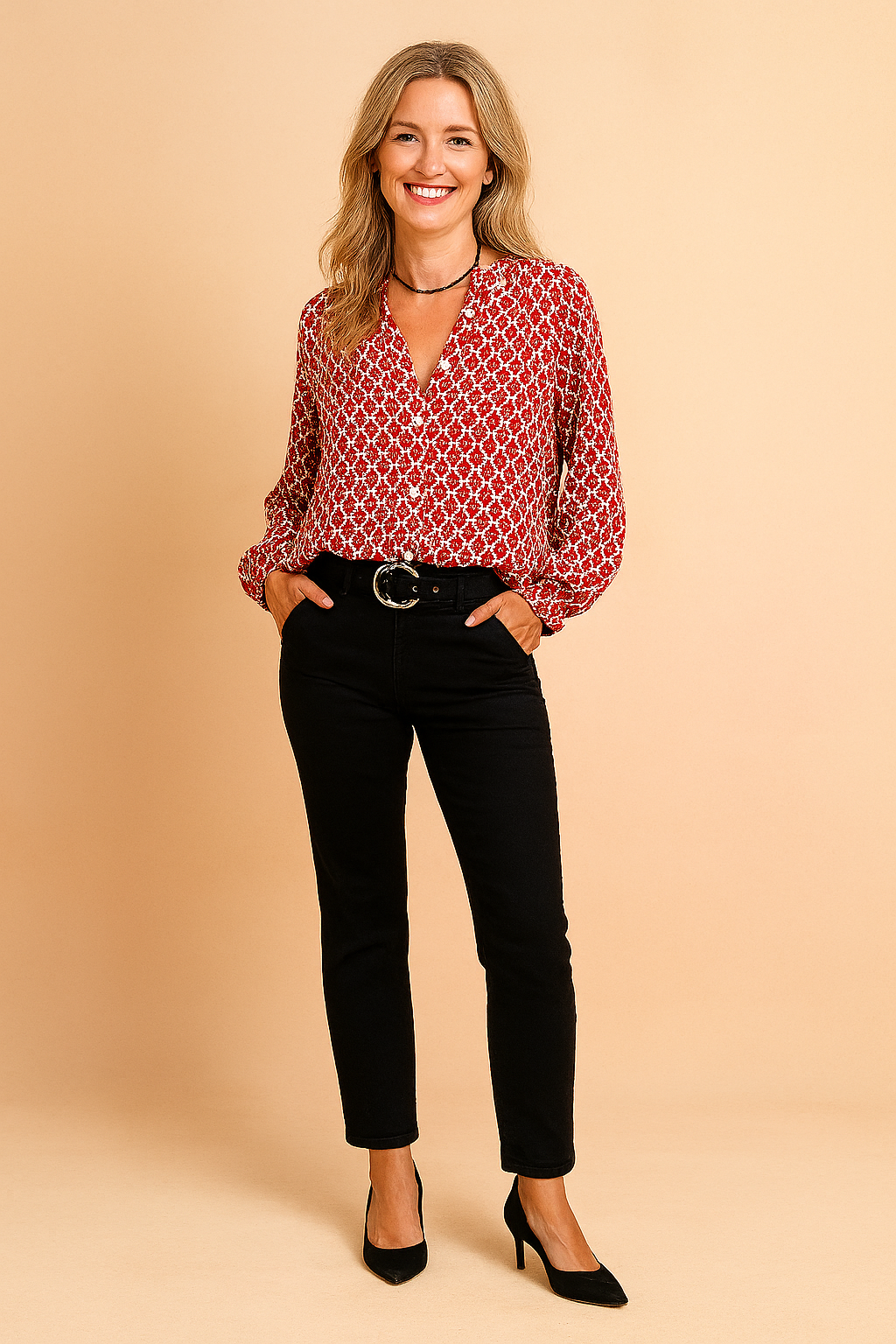 Long-sleeve red blouse with a white geometric pattern, featuring a button-down front and relaxed fit, paired with high-waisted black pants and a black belt with a round metallic buckle.