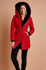 Red puffer winter jacket with oversized asymmetrical hood and black plush lining, featuring front zipper closure and zippered side pockets.