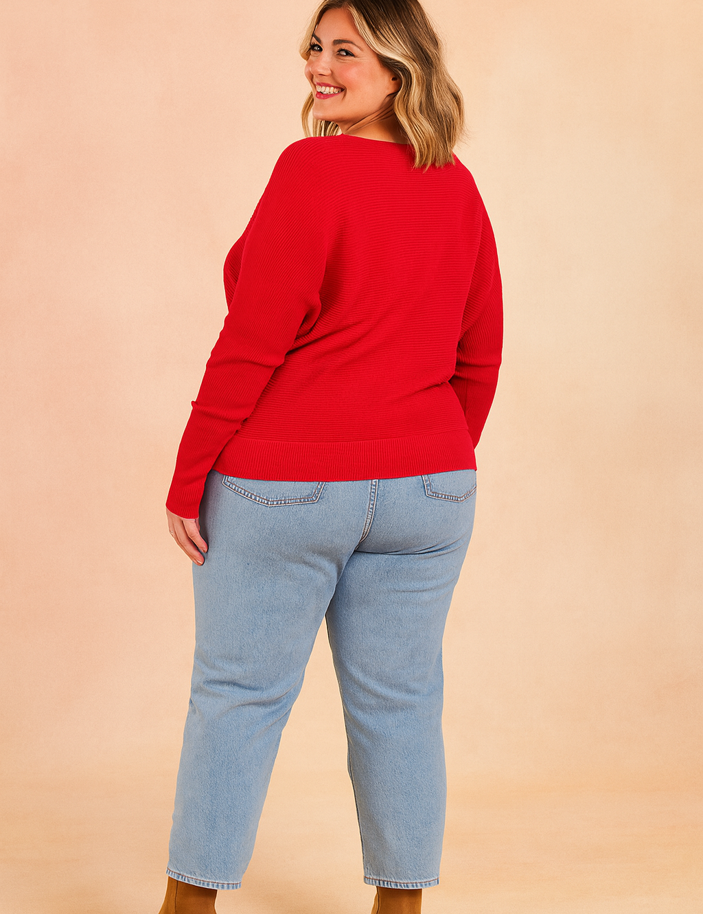 Vibrant red ribbed sweater paired with light blue straight-leg jeans and tan suede ankle boots.